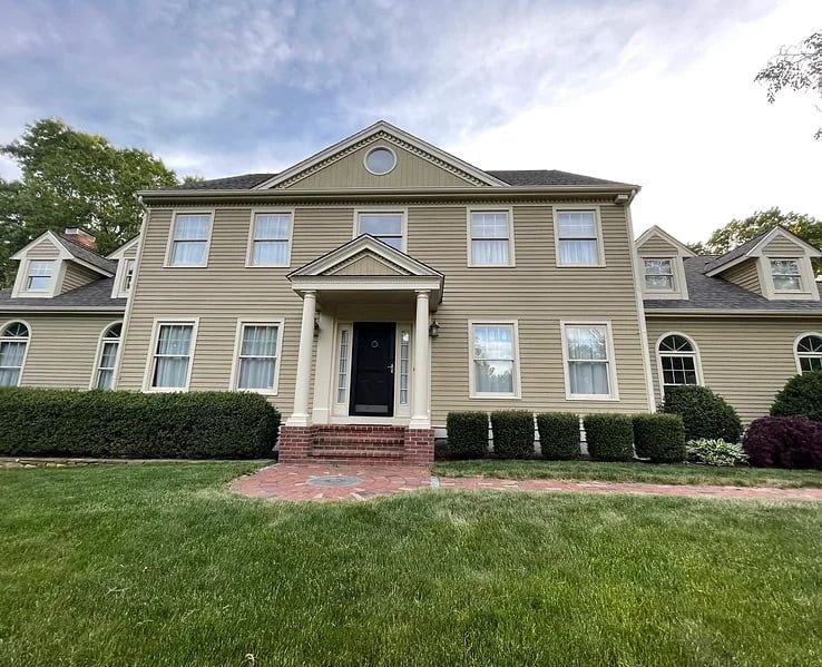 Tan colonial house with white trim