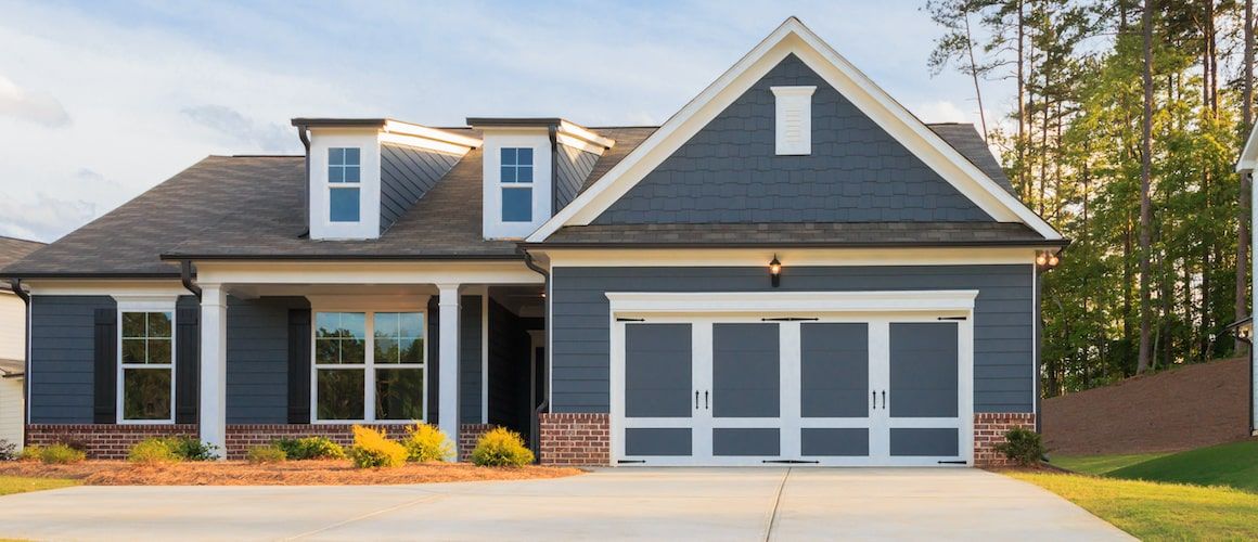 Navy blue house exterior with a white garage door