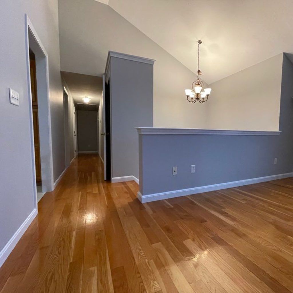 Hallway with freshly painted gray walls and hardwood floors