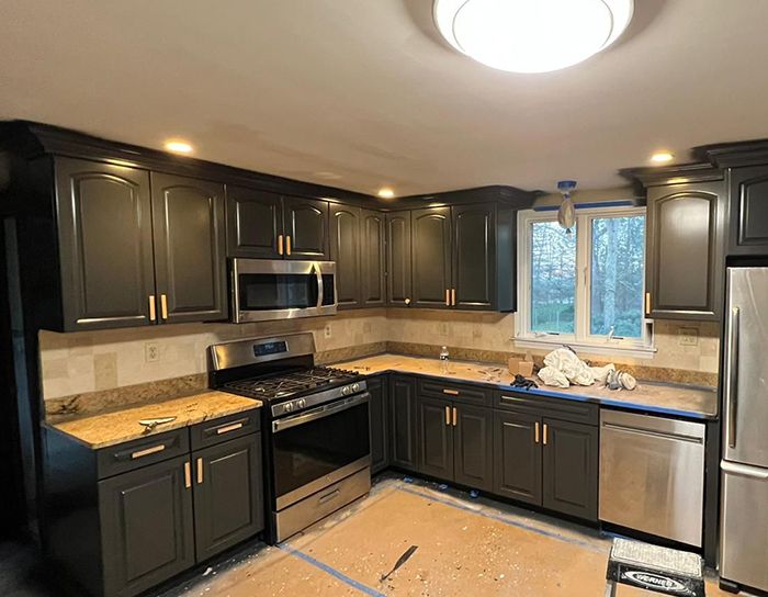 Kitchen cabinets refinished in charcoal with gold hardware