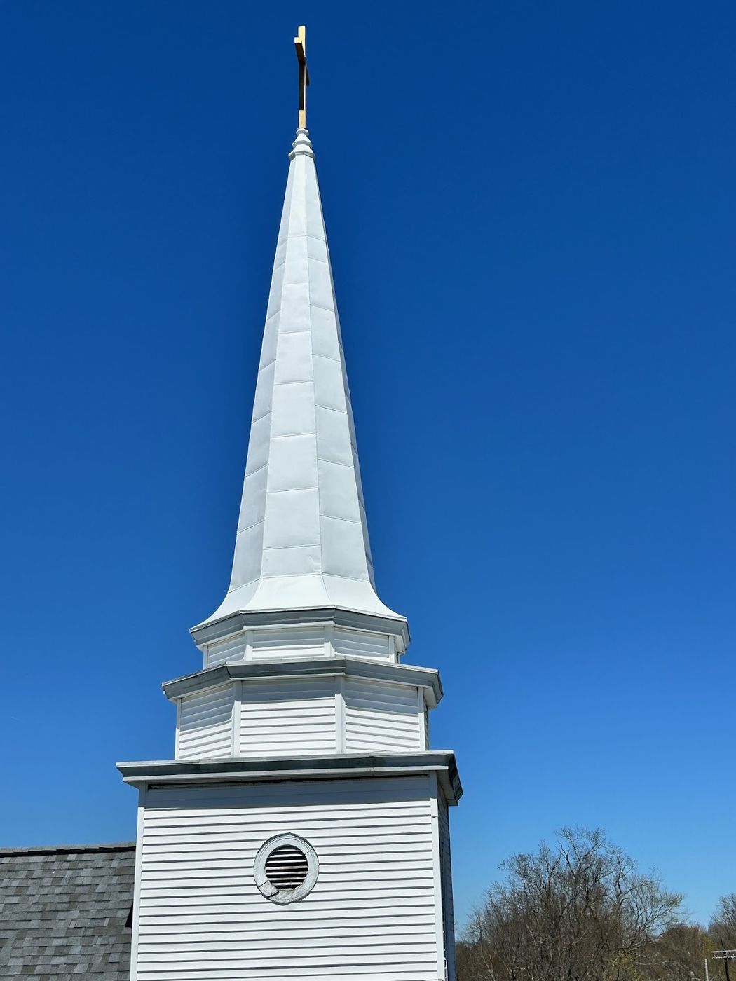 Freshly painted white church steeple against a blue sky